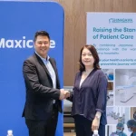 Shinagawa Diagnostic & Preventive Care representative and Maxicare executive shake hands in front of branded banners, symbolizing renewed partnership for advanced patient care.