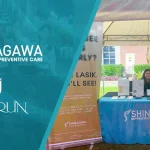 Shinagawa Diagnostic & Preventive Care team at an outdoor health booth during the Enderun campus event, showcasing LASIK services and preventive care brochures.