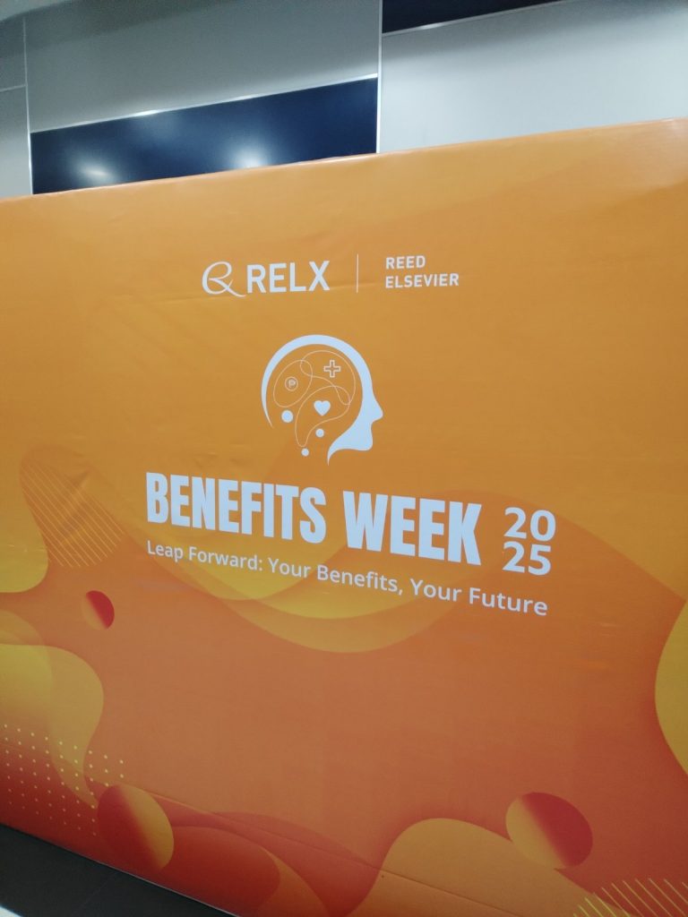 Orange event backdrop for RELX Reed Elsevier Benefits Week 2025 with the theme “Leap Forward: Your Benefits, Your Future,” promoting employee wellness and benefits awareness.